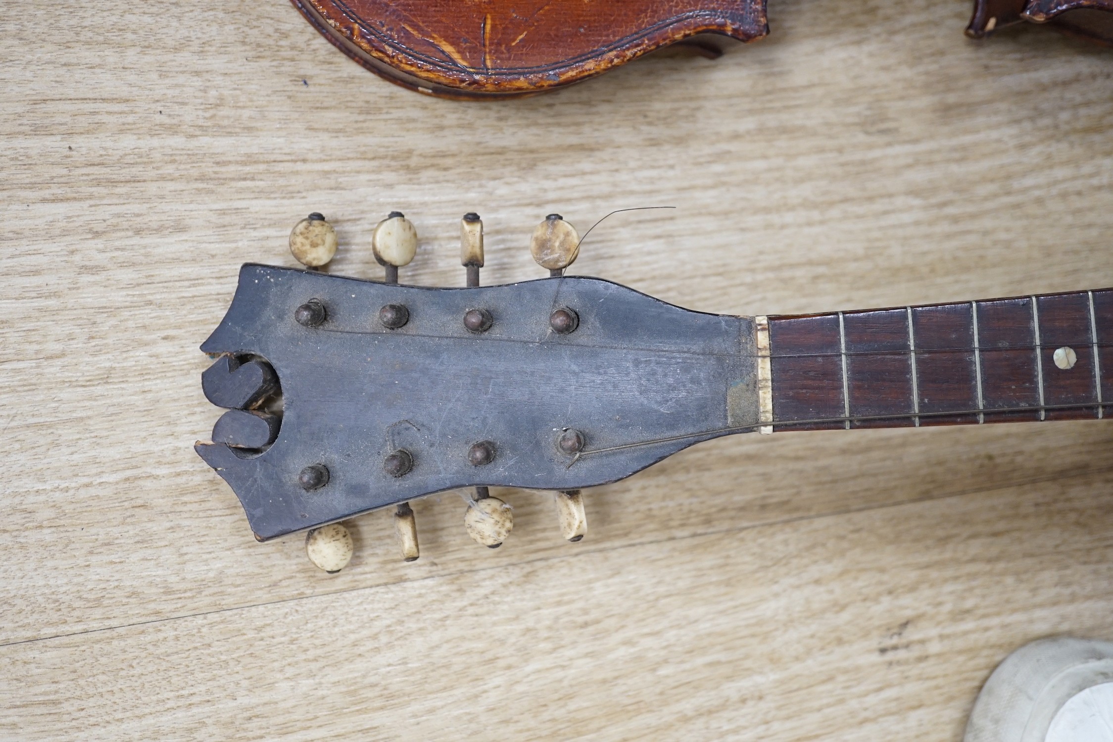 An Italian balloon back mandolin with tortoiseshell overlay, circa 1900, label for Pietro Tonelli of Napoli together with a violin, interior hand label reads ‘A.J. Newland London SW12 1939’ length of violin back excludin